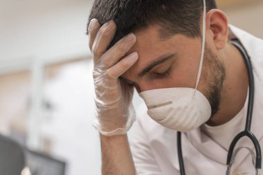 Koronavirüs salgını. Hastane kliniğinde Coronavirus 'la (2019-nCoV) uzun vardiya savaşından sonra yorgun düşmüş doktor. Dünya çapında küresel SARS-CoV-2 salgını.