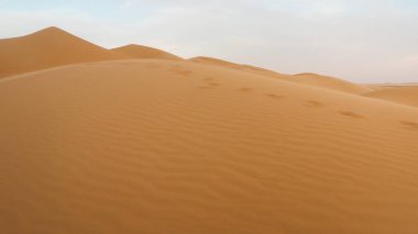 İnanılmaz çöl batımı. Sıcak renkleriyle güzel bir Arap çölü. Abu Dabi 'deki kum tepelerinin renkli hatları. 