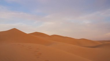 İnanılmaz çöl batımı. Sıcak renkleriyle güzel bir Arap çölü. Abu Dabi 'deki kum tepelerinin renkli hatları. 