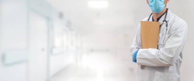 Coronavirus. Doktorlar hastanede çalışıyor ve koronavirüsle savaşıyorlar. Koruyucu kıyafetli ve maskeli bir erkek doktor hastalığın tedavisini arıyor. Metni kopyala Hastane geçmişi. Pankart.
