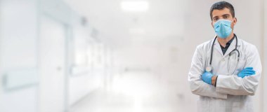 Coronavirus. Doktorlar hastanede çalışıyor ve koronavirüsle savaşıyorlar. Koruyucu kıyafetli ve maskeli bir erkek doktor hastalığın tedavisini arıyor. Metni kopyala Hastane geçmişi. Pankart.