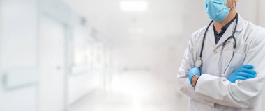 Coronavirus. Doktorlar hastanede çalışıyor ve koronavirüsle savaşıyorlar. Koruyucu kıyafetli ve maskeli bir erkek doktor hastalığın tedavisini arıyor. Metni kopyala Hastane geçmişi. Pankart.