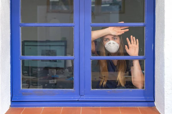 コロナウイルス 窓から見えるコロナウイルスの病気の女性と自宅で病気からマスクの保護と回復を身に着けています 隔離だ 感染を防ぐために隔離された患者 — ストック写真