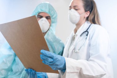 Coronavirus. Hastanede çalışan ve koronavirüsle savaşan doktor ve hemşirelerin portresi. Doktorlar kahramandır. Koruyucu giysili ve maskeli doktorlar hastalığın tedavisini arıyorlar.. 