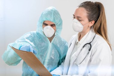 Coronavirus. Hastanede çalışan ve koronavirüsle savaşan doktor ve hemşirelerin portresi. Doktorlar kahramandır. Koruyucu giysili ve maskeli doktorlar hastalığın tedavisini arıyorlar.. 