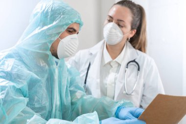 Coronavirus. Hastanede çalışan ve koronavirüsle savaşan doktor ve hemşirelerin portresi. Doktorlar kahramandır. Koruyucu giysili ve maskeli doktorlar hastalığın tedavisini arıyorlar.. 