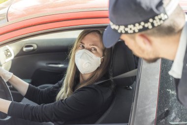Coronavirus. Tam korumalı ekipmanlı bir polis teknisyeni arabasında oturan genç bir kadından örnek alıyor. Coronavirus mobil test ünitesi. İzole edilmiş. Karantina. 