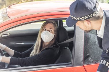 Coronavirus. Tam korumalı ekipmanlı bir polis teknisyeni arabasında oturan genç bir kadından örnek alıyor. Coronavirus mobil test ünitesi. İzole edilmiş. Karantina. 