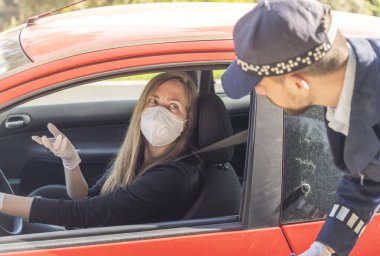Coronavirus. Tam korumalı ekipmanlı bir polis teknisyeni arabasında oturan genç bir kadından örnek alıyor. Coronavirus mobil test ünitesi. İzole edilmiş. Karantina. 