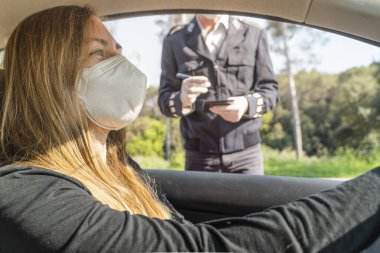Coronavirus. Tam korumalı ekipmanlı bir polis teknisyeni arabasında oturan genç bir kadından örnek alıyor. Coronavirus mobil test ünitesi. İzole edilmiş. Karantina. 