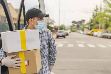 Coronavirus. Koruyucu maskeli ve lastik eldivenli adam teslimat hizmeti veriyor. Karantina altında teslimat hizmeti, salgın hastalık, koronavirüs salgını. Ulaşım. Kahramanlar. 