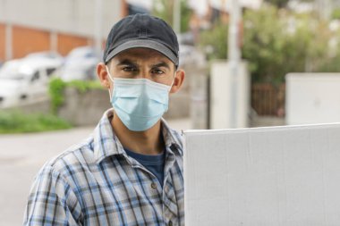Coronavirus. Koruyucu maskeli ve lastik eldivenli adam teslimat hizmeti veriyor. Karantina altında teslimat hizmeti, salgın hastalık, koronavirüs salgını. Ulaşım. Kahramanlar. 