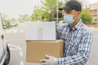 Coronavirus. Koruyucu maskeli ve lastik eldivenli adam teslimat hizmeti veriyor. Karantina altında teslimat hizmeti, salgın hastalık, koronavirüs salgını. Ulaşım. Kahramanlar. 