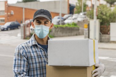 Coronavirus. Koruyucu maskeli ve lastik eldivenli adam teslimat hizmeti veriyor. Karantina altında teslimat hizmeti, salgın hastalık, koronavirüs salgını. Ulaşım. Kahramanlar. 
