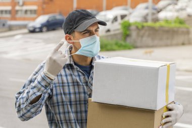 Coronavirus. Koruyucu maskeli ve lastik eldivenli adam teslimat hizmeti veriyor. Karantina altında teslimat hizmeti, salgın hastalık, koronavirüs salgını. Ulaşım. Kahramanlar. 