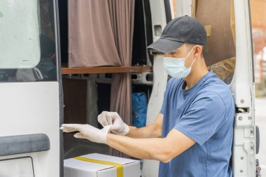 Coronavirus. Koruyucu maskeli ve lastik eldivenli adam teslimat hizmeti veriyor. Karantina altında teslimat hizmeti, salgın hastalık, koronavirüs salgını. Ulaşım. Kahramanlar. 