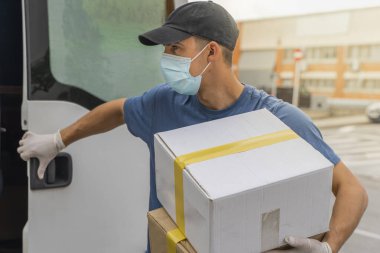 Coronavirus. Koruyucu maskeli ve lastik eldivenli adam teslimat hizmeti veriyor. Karantina altında teslimat hizmeti, salgın hastalık, koronavirüs salgını. Ulaşım. Kahramanlar. 