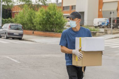 Coronavirus. Koruyucu maskeli ve lastik eldivenli adam teslimat hizmeti veriyor. Karantina altında teslimat hizmeti, salgın hastalık, koronavirüs salgını. Ulaşım. Kahramanlar. 