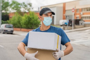 Coronavirus. Koruyucu maskeli ve lastik eldivenli adam teslimat hizmeti veriyor. Karantina altında teslimat hizmeti, salgın hastalık, koronavirüs salgını. Ulaşım. Kahramanlar. 