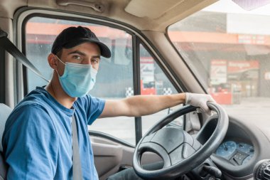 Coronavirus. Koruyucu maskeli ve lastik eldivenli adam teslimat hizmeti veriyor. Karantina altında teslimat hizmeti, salgın hastalık, koronavirüs salgını. Ulaşım. Kahramanlar. 