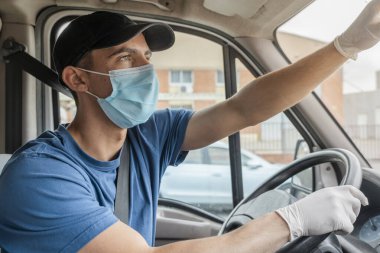 Coronavirus. Koruyucu maskeli ve lastik eldivenli adam teslimat hizmeti veriyor. Karantina altında teslimat hizmeti, salgın hastalık, koronavirüs salgını. Ulaşım. Kahramanlar. 
