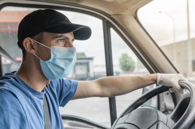 Coronavirus. Koruyucu maskeli ve lastik eldivenli adam teslimat hizmeti veriyor. Karantina altında teslimat hizmeti, salgın hastalık, koronavirüs salgını. Ulaşım. Kahramanlar. 