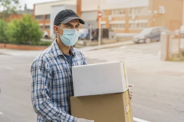 Coronavirus. Koruyucu maskeli ve lastik eldivenli adam teslimat hizmeti veriyor. Karantina altında teslimat hizmeti, salgın hastalık, koronavirüs salgını. Ulaşım. Kahramanlar. 