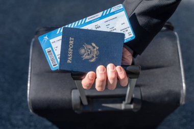 Coronavirus. Hava yolcusu maske takan bir iş adamı güneş ışığıyla havaalanında yürüyor. İş adamı sağlığını korumak için maske takar. Seyahat emniyeti. Pasaport. Uçuş kartı..