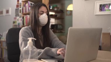 Coronavirus. İş kadını koruyucu maske takarak evde çalışıyor..