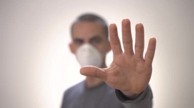 Coronavirus konsepti. COVID-19. Beyaz arka planda koruma maskesi olan genç bir adam. Virüs kavramını yavaş çekimde durdur. Evde izole edilmiş. Hapis cezasına çarptırıldı. Sosyal uzaklık. Grip..
