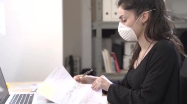 Coronavirus. İş adamları koruyucu maske takarak evde çalışıyor. Coronavirus için karantinada küçük bir şirket dezenfektan jeliyle çalışıyor. Küçük şirket konsepti.