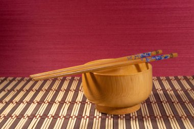 Çin yemek çubukları ahşap tabak ve kırmızı arka plan