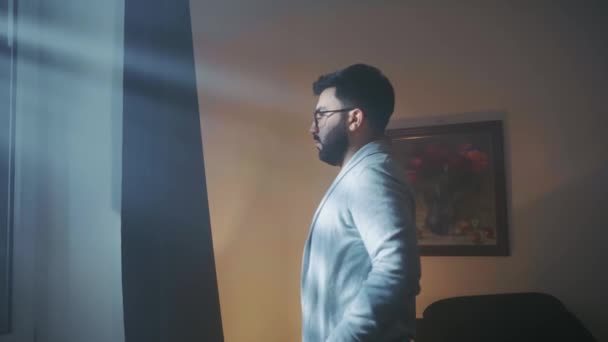 Muž se v noci dívá z okna — Stock video