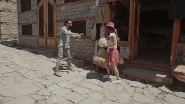 Para kochanków w luźnych ciuchach spaceruje trzymając się za ręce Wąska ulica Starego Miasta — Wideo stockowe