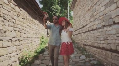 Gündelik giyinen bir çift sevgili yürüyüş yapar ve selfie çekeriz.
