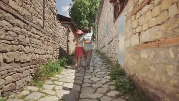 Пара влюбленных в повседневной одежде ходить и сделать селфи старой улице — стоковое видео