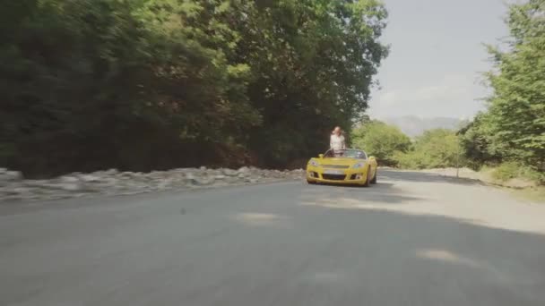 Счастливая пара за рулем автомобиля на лесной дороге — стоковое видео