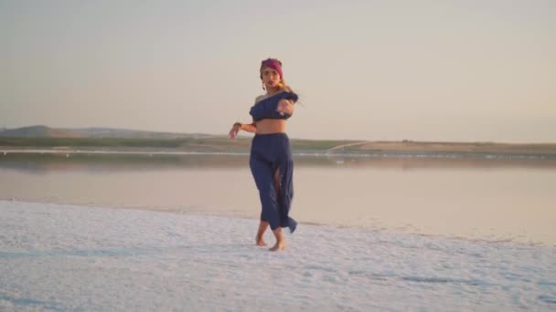 Joven bailarina junto al lago al atardecer — Vídeos de Stock