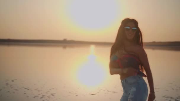 Молодая танцовщица у озера на закате — стоковое видео