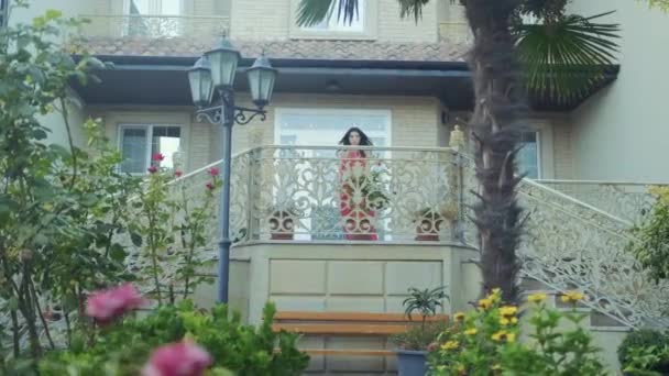 Belle fille en robe rouge marche seule dans le jardin vert — Video