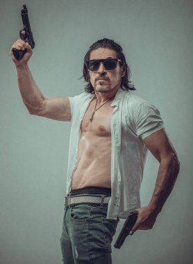 Elinde silah tutan genç bir adamın kaslı vücut modeli portresi.