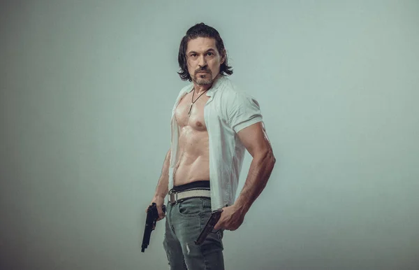 Elinde silah tutan genç bir adamın kaslı vücut modeli portresi.