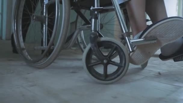 Enfermeira feminina empurrando o paciente na cadeira de rodas através do corredor do hospital — Vídeo de Stock