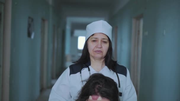 Female Nurse Pushing Patient In The Wheelchair Through The Hospital Corridor — Stock Video