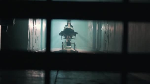 Infermiera donna che spinge paziente sulla sedia a rotelle attraverso il corridoio dell'ospedale — Video Stock