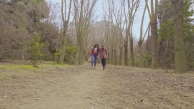 Mutlu bir çift parkta yürüyor ve dışarıda romantik bir çifti kucaklıyor.