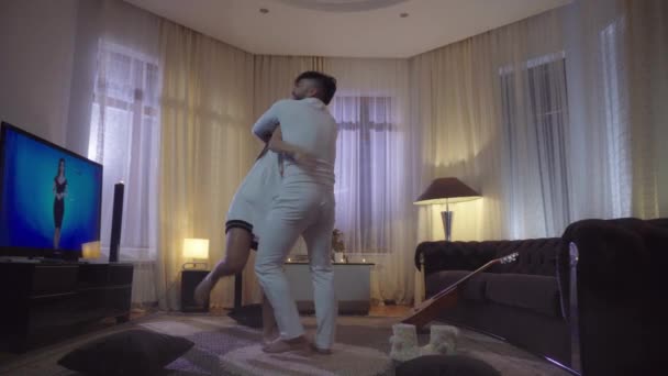 Joven pareja atractiva bailando en casa habitación de noche — Vídeo de stock