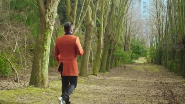 Trieste kerel loopt in het park — Stockvideo