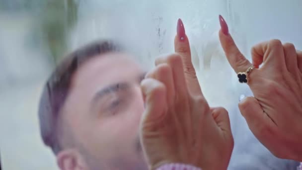Девушки рука рисует сердце на окне — стоковое видео