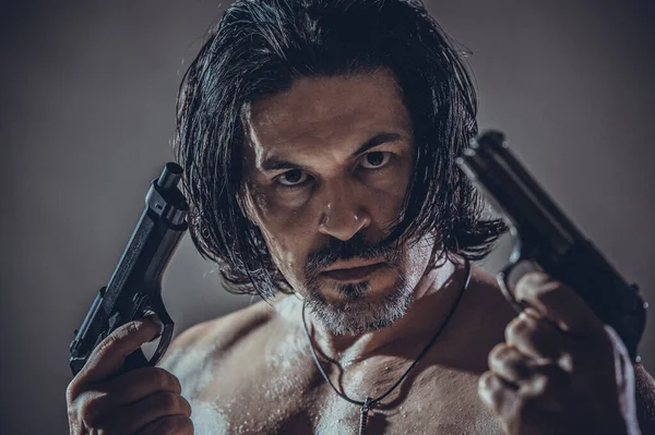Elinde silah tutan genç bir adamın kaslı vücut modeli portresi..